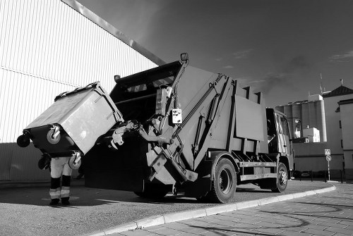 Commercial waste removal crew in Feltham loading a van outside a shop